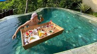 Liburan ke Ubud, Rezky menikmati floating breakfast. Sensasi sarapan sambil berenang pasti menyenangkan ya!