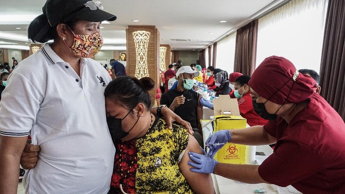 VAKSINASI ATLET PON XX PAPUA Reaksi seorang atlet Papua saat disuntik vaksin COVID-19 oleh petugas medis di Wisma Atlit Mandala Jayapura, Kota Jayapura, Papua, Sabtu (19/6/2021). Koordinator medis Komite Olahraga Nasional Indonesia (KONI) Papua Billy Haumasse mengatakan tahap pertama vaksinasi kepada atlet Papua, panitia PON XX Papua dan official-official, hari pertama mencapai 300-an orang, sedangkan yang tak memenuhi syarat vaksin berjumlah 10 orang. ANTARA FOTO/Indrayadi TH/rwa.