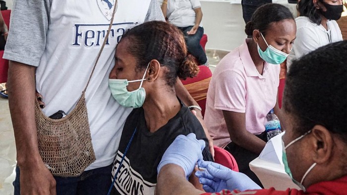 Reaksi seorang atlet Papua saat disuntik vaksin COVID-19 oleh petugas medis di Wisma Atlit Mandala Jayapura, Kota Jayapura, Papua, Sabtu (19/6/2021). Koordinator medis Komite Olahraga Nasional Indonesia (KONI) Papua Billy Haumasse mengatakan tahap pertama vaksinasi kepada atlet Papua, panitia PON XX Papua dan official-official, hari pertama mencapai 300-an orang, sedangkan yang tak memenuhi syarat vaksin berjumlah 10 orang. ANTARA FOTO/Indrayadi TH/rwa.