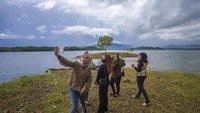 Pengunjung berswafoto dengan latar belakang Waduk Riam Kanan di Kawasan Wisata Bukit Batu, Desa Sungai Luar Tiwingan Baru, Kabupaten Banjar, Kalimantan Selatan, Sabtu (19/6/2021). 
