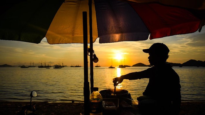 Pedagang menunggu pembeli di Pantai Pede, Labuan Bajo, Manggarai Barat, Nusa Tenggara Timur, Sabtu (19/6/2021). Sebagian warga di Labuan Bajo menjadikan pantai tersebut sebagai wisata alternatif pada akhir pekan. ANTARA FOTO/Rivan Awal Lingga/rwa.