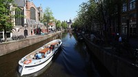 Amsterdam merupakan destinasi favorit turis di Belanda. Suasana kota yang khas dengan ratusan kanal dan kehidupan masyarakat yang gemar naik sepeda menjadi daya tariknya. Kehadiran kanal-kanal dan deretan bangunan berwarna-warni di kota terbesar Belanda itu menjadi salah satu faktor yang membuat Amsterdam jadi salah satu kota tercantik di Eropa. Dean Mouhtaropoulos/Getty Images.