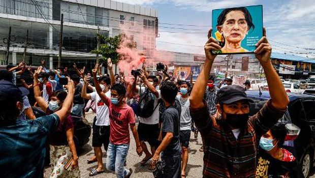 A protester holds up a painting of Myanmar's detained civilian leader Aung San Suu Kyi to mark her birthday during a demonstration against the military coup in Yangon on June 19, 2021. (Photo by STR / AFP)