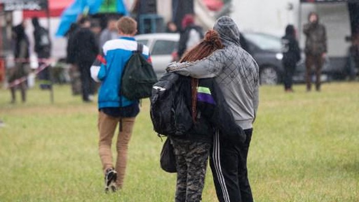 A couple hugs during an illegal rave party in a field in Redon, north-western France, on June 19, 2021. - Five police officers were injured overnight in western France as they broke up a 1,500-strong illegal rave, authorities said on June 19, 2021, with one partygoer losing a hand in the clashes. Defying an 11:00 pm coronavirus curfew, the group had attempted to set up the party at a horse racing track near Redon in Brittany. (Photo by LOIC VENANCE / AFP)