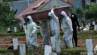 Sejumlah petugas tengah membawa peti jenazah pasien COVID-19 untuk dimakamkan di kawasan TPU Srengseng Sawah 2, Jakarta, Minggu (20/6/2021).