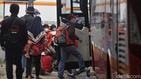 Satu per satu penumpang menaiki bus. 