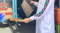 Menggunakan gamis berwarna putih, begini keseruan Syakir Daulay saat membakar sate sendiri di gerobak. Foto: Instagram @syakirdaulay