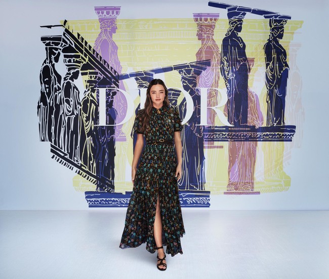 Model Miranda Kerr tak kalah eksis. Ia memakai shirt-dress hitam bermotif floral dari koleksi Dior Pre-Fall 2021 yang dipadu dengan slim belt nan chic. (Foto: Dok. Christian Dior)