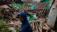 Seorang guru melintas di sekitar ruang kelas yang atapnya runtuh di Madrasah Ibtidaiyah Riyadus Sibyan, Lebak, Banten, Senin (21/6/2021).   
