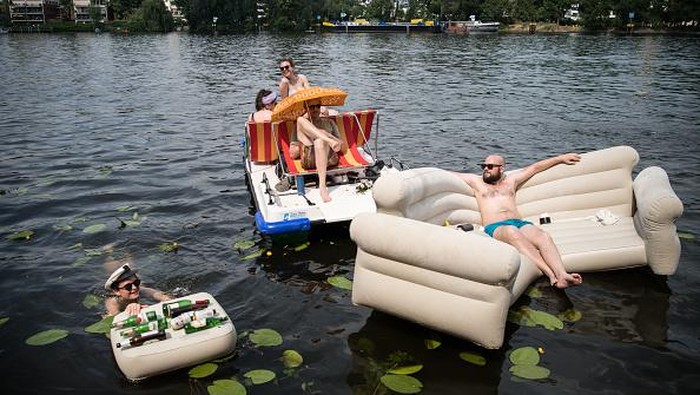 Cara Warga Jerman Menghalau Gerah MARIENWERDER, GERMANY - JUNE 19: People relax on the beach and on inflatable floats at Bernsteinsee lake during hot weather June 19, 2021 near Marienwerder, Germany. Temperatures are reaching 36 degrees Celsius across large parts of Germany over the weekend.