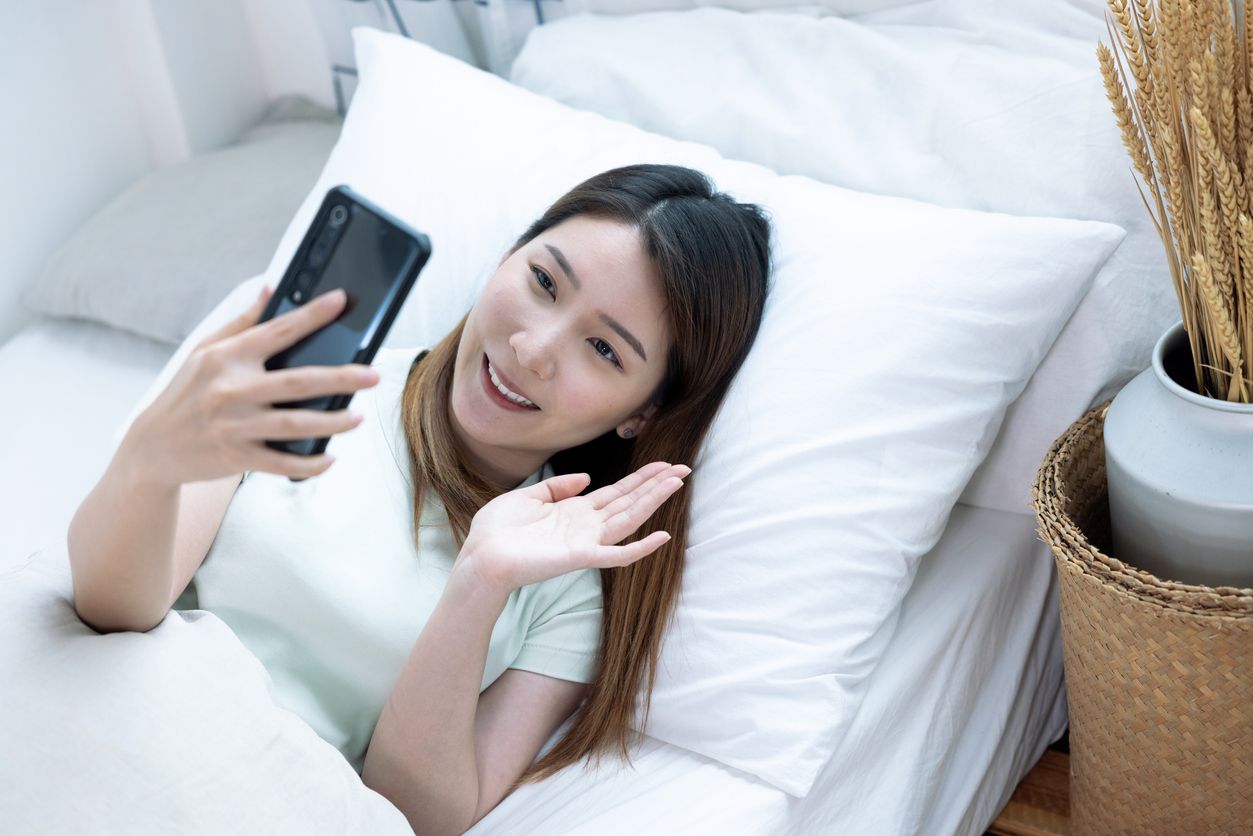 Asian woman using smartphone for video call, looking at screen of smartphone, Modern technologies and communication.