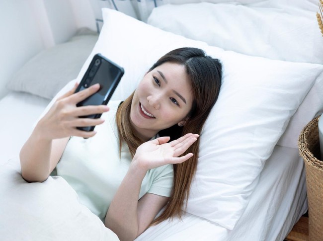 Asian woman using smartphone for video call, looking at screen of smartphone, Modern technologies and communication.