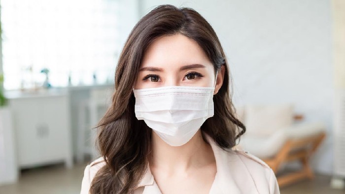 Ilustrasi Memakai Masker Asian Woman wears a facial mask and she look you
