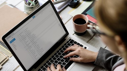 Businesswoman Checking E-mail Online on Laptop