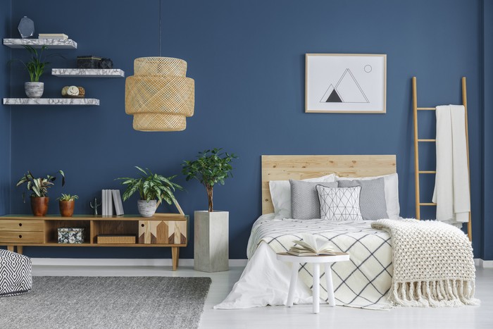 Ilustrasi Ruangan Biru Cozy bedroom interior with a double bed, wooden cabinet, chandelier and blue wall