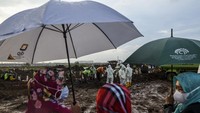 Para kerabat korban COVID-19 hanya bisa menyaksikan pemakaman jenazah dari kejauhan, karena pemakaman dilakukan dengan protokol ketat di TPU Rorotan, Cilincing, Jakarta Utara. 