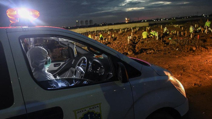 Petugas bersiap menurunkan jenazah yang akan dimakamkan dengan protokol COVID-19 dari dalam mobil ambulans di TPU Rorotan, Cilincing, Jakarta Utara, Senin (21/6/2021). Data Satuan Tugas Penanganan COVID-19 per hari Senin (21/6) menyebutkan kasus positif COVID-19 bertambah 14.536 orang sehingga total menjadi 2.004.445 orang, sementara kasus pasien sembuh bertambah 9.233 orang menjadi 1.801.761 orang, dan kasus meninggal akibat COVID-19 bertambah 294 jiwa sehingga totalnya menjadi 54.956 jiwa. ANTARA FOTO/M Risyal Hidayat/wsj.