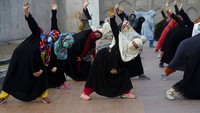 Para wanita mengikuti sesi yoga di area luar Taman Shalimar di Lahore, Pakistan. AP Photo/K.M. Chaudary  