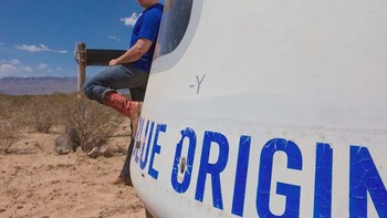 Jeff Bezos bergaya di depan kapsul New Shepard yang akan melesatkannya ke orbit Bumi. Foto: Blue Origin