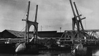 Penampakan jembatan angkat di Batavia yang dipotret sekitar tahun 1940-an. Pada masa kolonial Hindia, sejumlah jembatan dibangun di kawasan Batavia untuk menjadi penghubung satu daerah dengan daerah lainnya yang terpisah kali atau sungai. Salah satu jembatan tertua di Jakarta yang hingga kini masih dapat dilihat keberadaannya adalah Jembatan Kota Intan. Sempat rusak imbas penyerangan Banten dan Mataram pada tahun 1628-1629, jembatan ini dibangun kembali oleh Belanda pada tahun 1630. Fox Photos/Getty Images.  