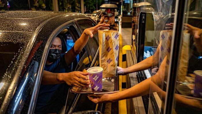 Semarak BTS Meal di McD Filipina SAN FERNANDO, PHILIPPINES - JUNE 18: A customer poses for a picture wearing a mask with the face of Jungkook of BTS, during the launch of the BTS Meal at a McDonald's restaurant on June 18, 2021 in San Fernando, Pampanga province, Philippines. Long queues formed in several McDonald's restaurants in the Philippines as fans of the K-pop group BTS flocked to order the newly launched and wildly popular BTS themed meals. The limited edition celebrity meal