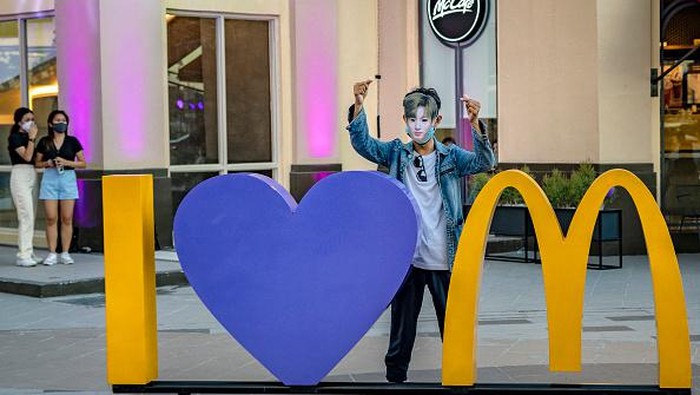 Semarak BTS Meal di McD Filipina SAN FERNANDO, PHILIPPINES - JUNE 18: A customer poses for a picture wearing a mask with the face of Jungkook of BTS, during the launch of the BTS Meal at a McDonald's restaurant on June 18, 2021 in San Fernando, Pampanga province, Philippines. Long queues formed in several McDonald's restaurants in the Philippines as fans of the K-pop group BTS flocked to order the newly launched and wildly popular BTS themed meals. The limited edition celebrity meal