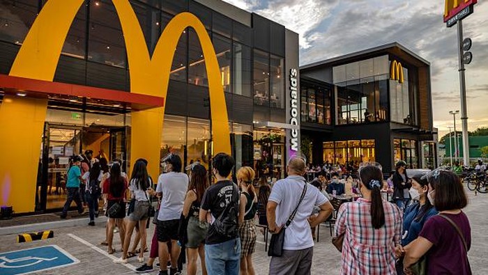 SAN FERNANDO, PHILIPPINES - JUNE 18: A customer poses for a picture wearing a mask with the face of Jungkook of BTS, during the launch of the BTS Meal at a McDonald's restaurant on June 18, 2021 in San Fernando, Pampanga province, Philippines. Long queues formed in several McDonald's restaurants in the Philippines as fans of the K-pop group BTS flocked to order the newly launched and wildly popular BTS themed meals. The limited edition celebrity meal 