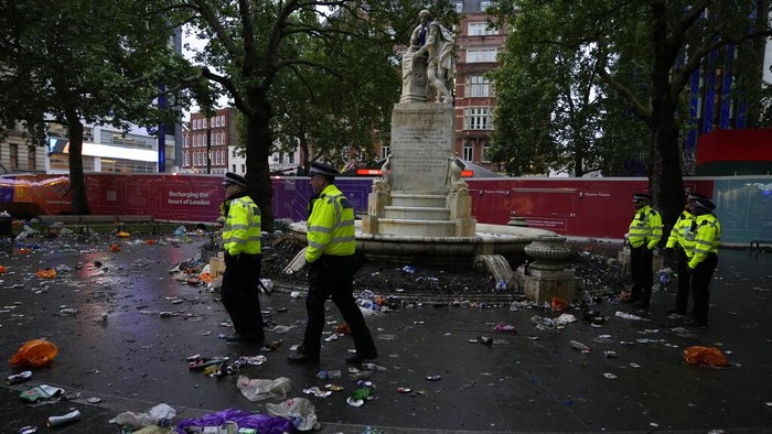 Police officers stand amongst rubbish left behind by partying Scotland fans near the statue to William Shakespeare in Leicester Square in London, Friday, June 18, 2021 prior to the Euro 2020 soccer championship group D match between England and Scotland at Wembley Stadium. (AP Photo/Kirsty Wigglesworth)