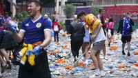 Suporter Skotlandia mulai memungut sampah setelah ribuan dari mereka berpesta di pusat kota London menjelang pertandingan melawan Inggris. AP Photo/Kirsty OConnor  
