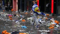 Seorang penggemar Skotlandia berjalan di tengah sampah di jalanan London, Inggris. AP Photo/Kirsty Wigglesworth  