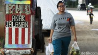 Terlihat seorang ibu melintasi jalan protokol di Jakarta tanpa masker. Sementara selama satu bulan terakhir, terhitung sejak 31 Mei 2021, ada 7 provinsi yang mencatat lonjakan kasus aktif COVID-19 tertinggi di Indonesia termasuk DKI Jakarta.