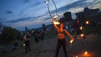 Para penampil dari Fire Club Edinburgh memamerkan aksinya bermain dengan tongkat yang dibakar dengan api.  