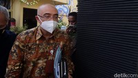 Bima tampak mengenakan kemeja batik cokelat dan terlihat menenteng sejumlah berkas.  