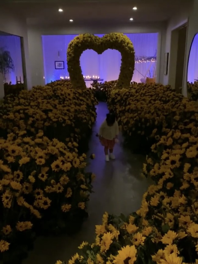 Hamparan bunga matahari lalu terlihat menghiasi area dalam rumah. Di bagian ujung, terdapat sebuah gerbang berbentuk hati yang masih terbuat dari bunga yang sama. (Foto: Instagram/@kyliejenner)