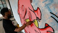 Seorang seniman tengah mengerjakan mural di Rumah Lawan COVID-19 (RLC) Tangsel, Selasa (22/6/2021).  