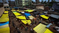 Orang-orang  berjalan di antara kios-kios di pasar grosir, negara bagian Uttar Pradesh, India, Senin (21/6/2021) waktu setempat.  