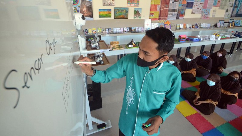 Seorang santri mengoperasikan robot Sabai menggunakan remote di kafe Arfa, Perguruan Diniyyah Putri Padangpanjang, Sumatera Barat.