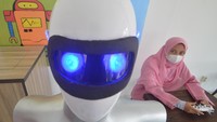 Seorang santri mengoperasikan robot Sabai menggunakan remote di kafe Arfa, Perguruan Diniyyah Putri Padangpanjang, Sumatera Barat.