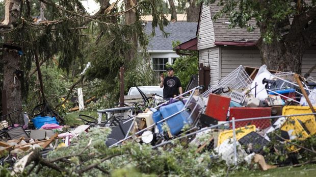 Kris Florczak, 70, salvages what she can from her home, including family photos and heirlooms, on Janes Avenue near Evergreen Lane in Woodridge, Ill., after a tornado ripped through the western suburbs overnight, Monday, June 21, 2021. (Ashlee Rezin Garcia/Chicago Sun-Times via AP)