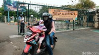 Salah seorang pemotor yang membawa keluarganya kembali pulang usai mengetahui Taman Margasatwa Ragunan ditutup. Ragunan tidak akan beroperasi sampai batas waktu yang belum ditentukan.