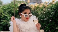 Selain menghabiskan waktu bersama teman-temannya, Nindy juga sangat gemar travelling. Ia terlihat cantik saat berfoto di sebuah kafe di Prancis lengkap dengan kacamata hitam dan gaun putih cantik yang dikenakannya. Foto: Instagram/nindyayunda