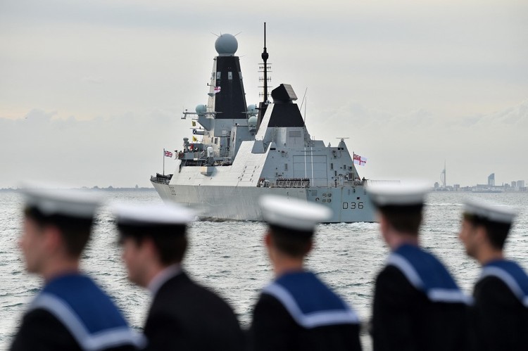 HMS Defender prepares to take part in a sail past to honour D-Day veterans on board the Royal British Legions ship MV Boudicca en route to Normandy, in the Solent during an event to commemorate the 75th anniversary of the D-Day landings, off the coast of southern England, on June 5, 2019. - US President Donald Trump, Queen Elizabeth II and 300 veterans are to gather on the south coast of England on Wednesday for a poignant ceremony marking the 75th anniversary of D-Day. Other world leaders will join them in Portsmouth for Britains national event to commemorate the Allied invasion of the Normandy beaches in France -- one of the turning points of World War II. (Photo by Glyn KIRK / AFP)