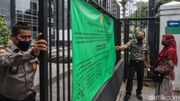 Petugas keamanan berjaga di gerbang Pengadilan Negeri (PN) Jakarta Pusat, Rabu (23/6/2021).