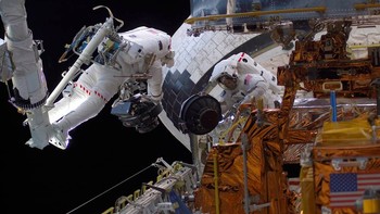 Selama Service Mission 3B pada Maret 2002, astronot Michael Massimino (kiri) dan James Newman (kanan) mengganti salah satu dari empat Reaction Wheel Assemblies Hubble, yang membantu menghidupkan pesawat ruang angkasa. Foto: NASA