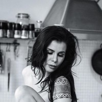 Seperti dalam foto bertema hitam putih ini. Tanpa mengenakan busana, Candida berpose di atas meja kayu di dapurnya. Foto: dok. Instagram