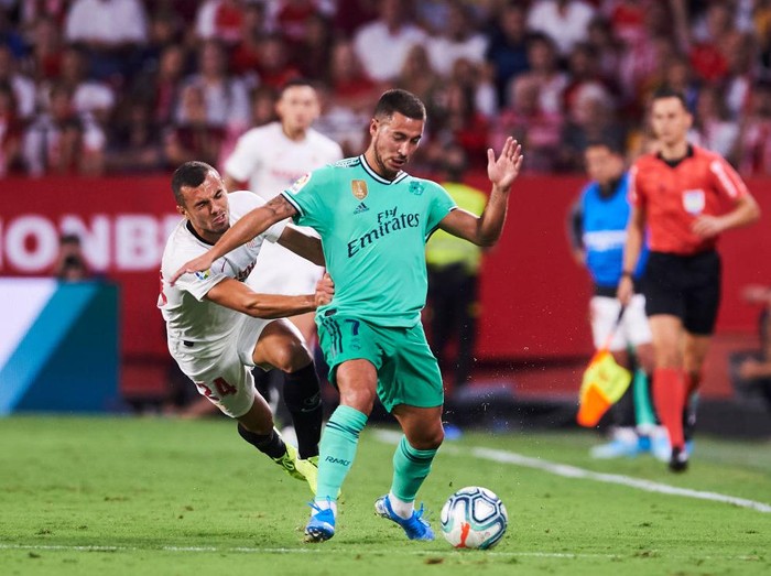 SEVILLE, SPAIN - SEPTEMBER 22: Eden Hazard of Real Madrid CF  duels for the ball with Joan Jordan of Sevilla FC during the Liga match between Sevilla FC and Real Madrid CF at Estadio Ramon Sanchez Pizjuan on September 22, 2019 in Seville, Spain. (Photo by Aitor Alcalde/Getty Images)