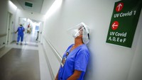 Seorang tenaga kesehatan berhenti sejenak di unit ICU untuk pasien COVID-19 di RS das Clínicas de Porto Alegre, Brasil (19/3).  Kementerian kesehatan Brasil melaporkan 115.228 kasus Corona tercatat dalam 24 jam terakhir di wilayahnya. Data terbaru kementerian juga melaporkan bahwa sedikitnya 2.392 kematian akibat Corona tercatat dalam sehari. AP/Jefferson Bernardes