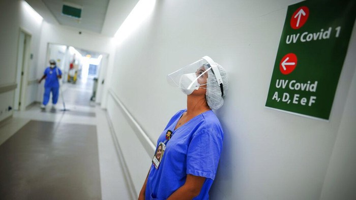 Gelombang Ketiga di Brazil, Sehari Tembus 115 Ribu Kasus Baru Corona FILE - In this March 19, 2021 file photo, a health worker pauses in the ICU unit for COVID-19 patients at the Hospital das Clinicas in Porto Alegre, Brazil. As Brazil hurtles toward an official COVID-19 death toll of 500,000 — second-highest in the world — science is on trial inside the country and the truth is up for grabs. (AP Photo/Jefferson Bernardes, File)