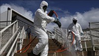 Petugas menyemprotkan cairan disinfektan di RS Parelheiros, São Paulo, Brasil (18/6). Getty Images/Rodrigo Paiva