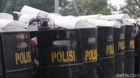 Sejumlah petugas kepolisian yang berjaga di sekitar Pengadilan Negeri Jakarta Timur, melindungi diri saat sejumlah massa melempar batu ke arah polisi jelang sidang vonis Habib Rizieq.